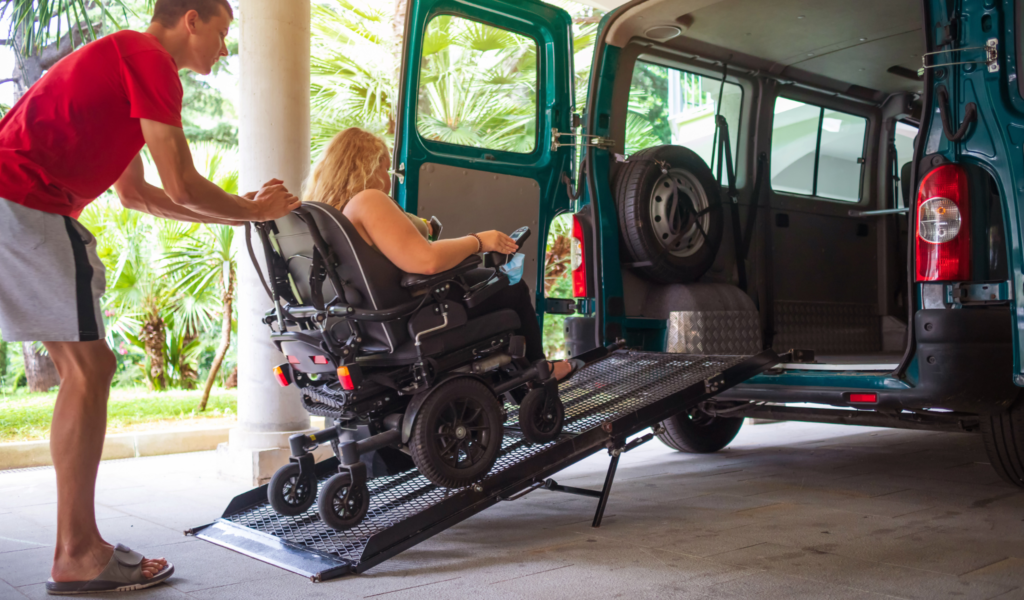 Planning accessible trip - a wheelchair user being guided up a ramp onto an accesible van.