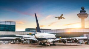 Image of an airport with planes loading and taking off. Secretary Buttigieg Announces Sweeping Protections for Airline Passengers with Disabilities.