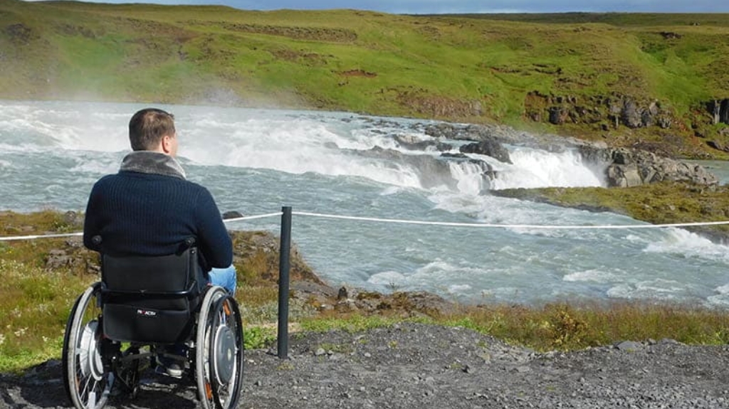 Wheelchair user overlooking Gullfoss Waterfall in Iceland during an accessible Golden Circle tour with Iceland Unlimited.