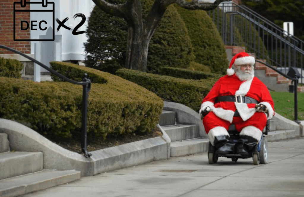 A man dressed as Santa Claus rides a powered wheelchair along a sidewalk beside a staircase and neatly trimmed hedges. The scene suggests inaccessibility, as the nearby stairs have no visible ramp alternative. A calendar icon marked "DEC x2" appears in the top left, likely referencing both Christmas and the International Day of Persons with Disabilities in December.