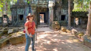 Jodie, an amputee traveler, exploring ancient ruins with a trekking pole — showcasing adaptive travel tips for amputees.