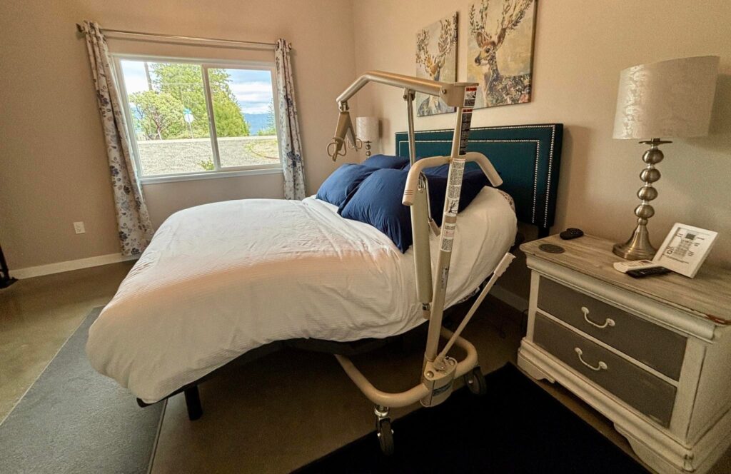 Wheelchair-accessible bedroom with a low-clearance bed and Invacare hydraulic patient lift for disabled travelers near Yosemite National Park