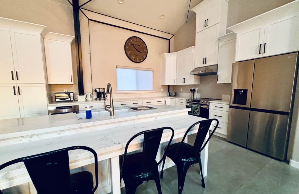 Spacious wheelchair-accessible kitchen with a lowered island, under-counter microwave, and accessible drawer of lightweight dish sets