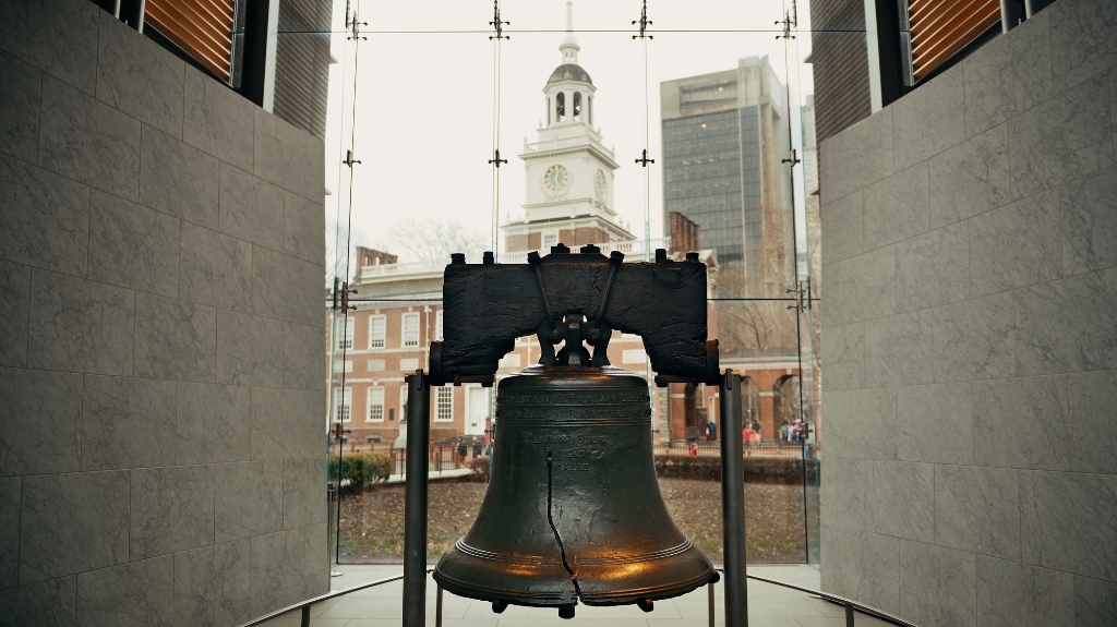 Close-up view of the Liberty Bell with Independence Hall visible, highlighting accessible historic sites in Philadelphia.