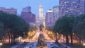 Evening view of Philadelphia skyline with City Hall and illuminated streets showcasing accessible travel opportunities.