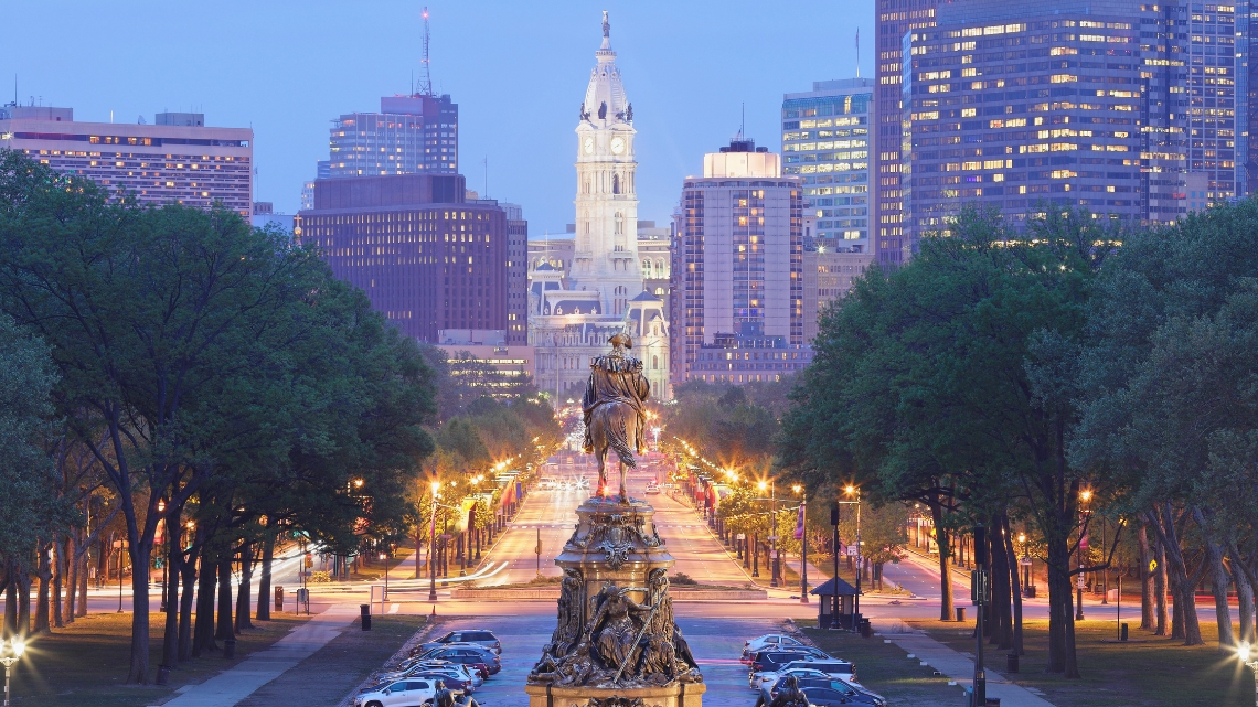 Evening view of Philadelphia skyline with City Hall and illuminated streets showcasing accessible travel opportunities.