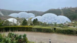 A rainy image of the Eden Project bio domes, from the outside. The domes are huge, housing a great number of plant species and exotic birds and animals.