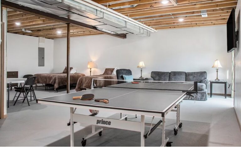 Spacious recreation room in the basement featuring a professional Prince ping-pong table, additional beds for extra guests, and a cozy sofa area.