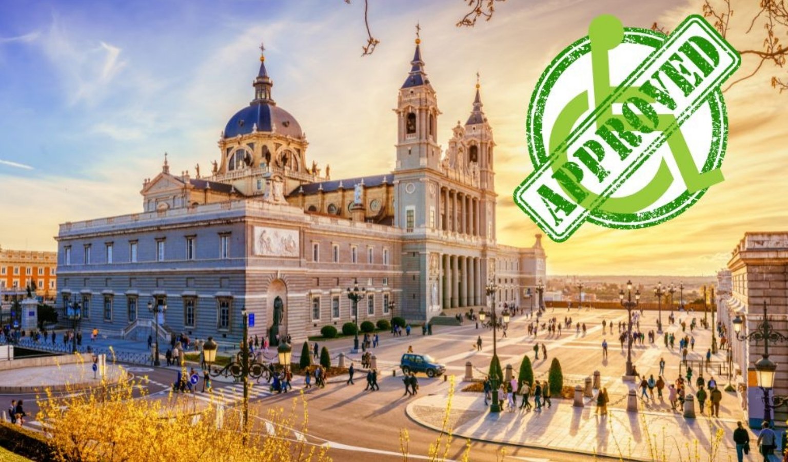 Exterior view of the accessible Almudena Cathedral in Madrid, Spain, with people walking and rolling across the spacious plaza at sunset