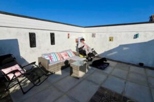 Wheelchair user relaxing on accessible patio with outdoor seating at Seahorses holiday bungalow in Brixham.