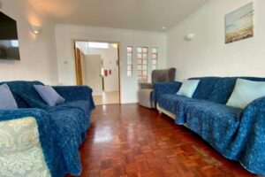 Accessible lounge at Seahorses holiday bungalow in Brixham, featuring rise-and-recline chair, spacious layout, and step-free flooring.