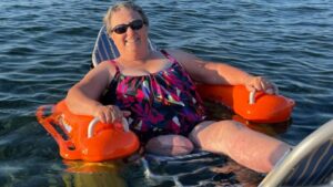 Maggie Tietjen, an amputee from Vancouver Island, Canada, relaxes in the ocean while using an adaptive beach chair.