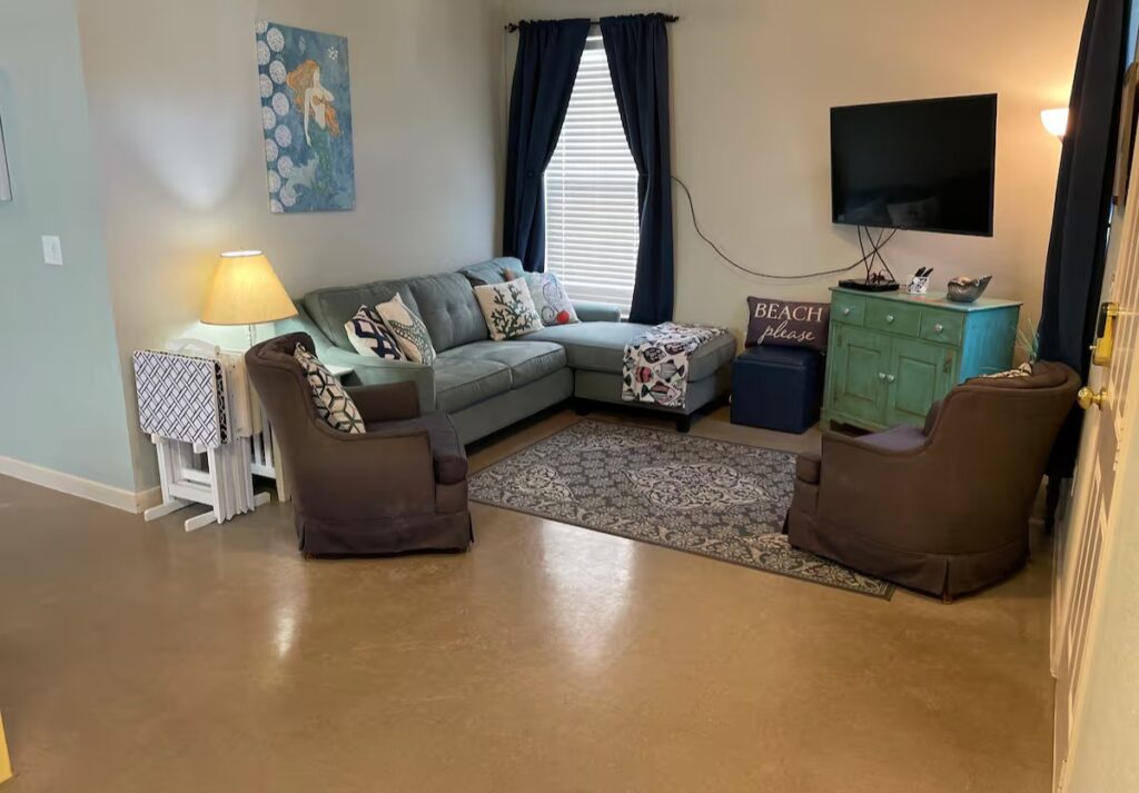 Step-free living room with sofa, TV, and coastal décor in accessible beach house Galveston.