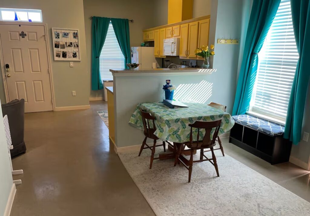 Open dining area with natural light and accessible flooring in Galveston beach rental.
