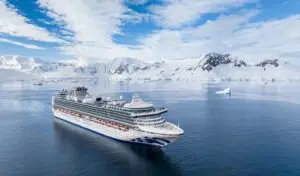 Feature image for 'Community Access Report: Cruise to Antarctica On The Sapphire Princess' article. Image includes the cruise ship, taken from above, with ice cliffs in the background.