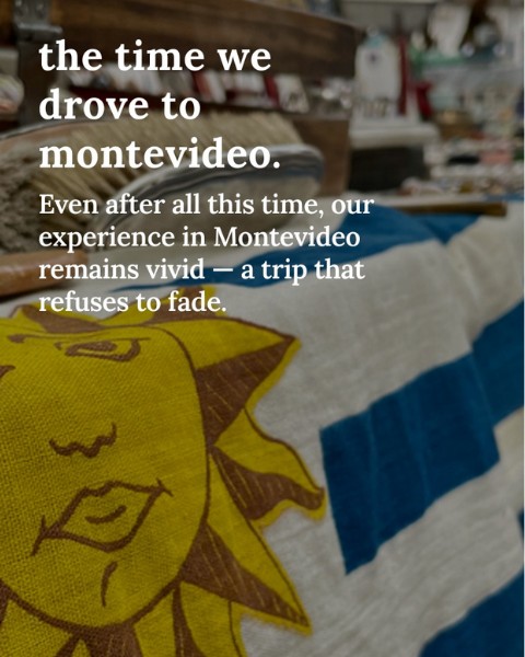 A close-up photo of a fabric item featuring the Uruguayan flag’s Sun of May in yellow and blue. Overlaid white text reads: “the time we drove to montevideo. Even after all this time, our experience in Montevideo remains vivid — a trip that refuses to fade.” The background is softly blurred, suggesting a shop or market setting.