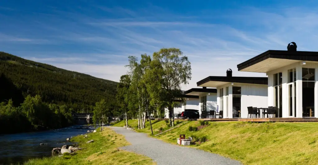 A walkway, by a river, with houses alongside it.