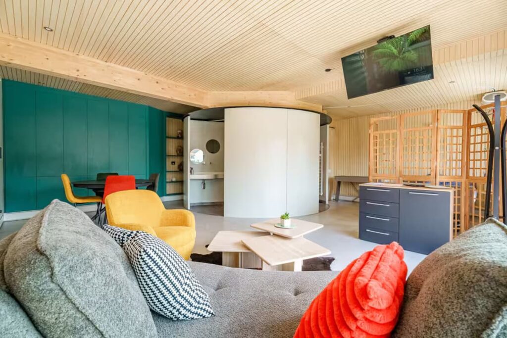 Open-concept living room featuring a ceiling-mounted rotating TV and wide pathways for seamless wheelchair navigation.