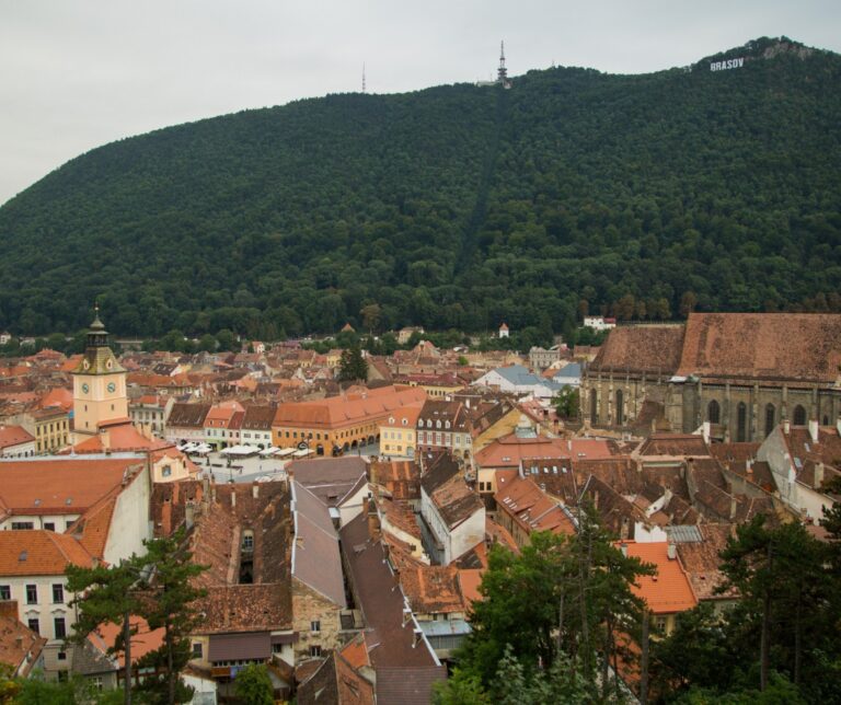 Panoramic view over the terracotta rooftops of Brașov old town, Transylvania, Romania, with Tampa Mountain and the Brasov sign visible above