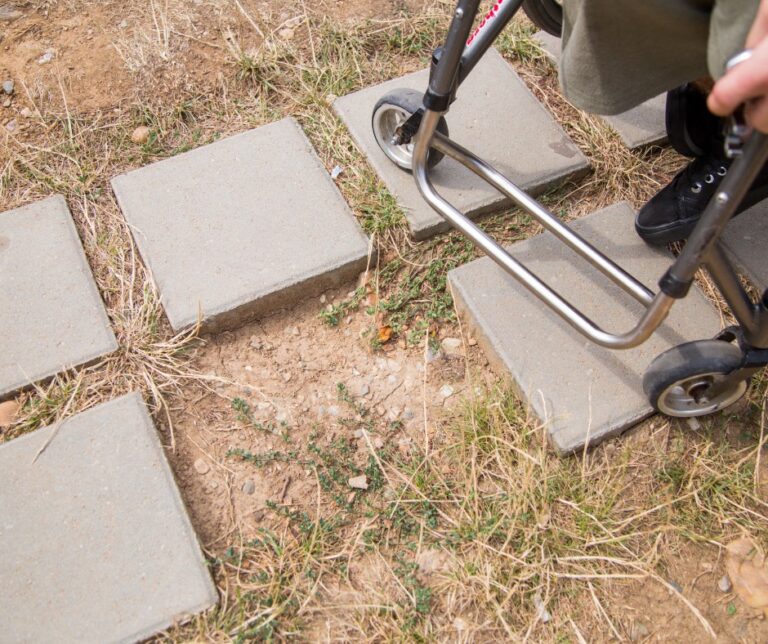 Wheelchair navigating uneven concrete paving slabs on a path in Romania, illustrating accessibility challenges for disabled travelers