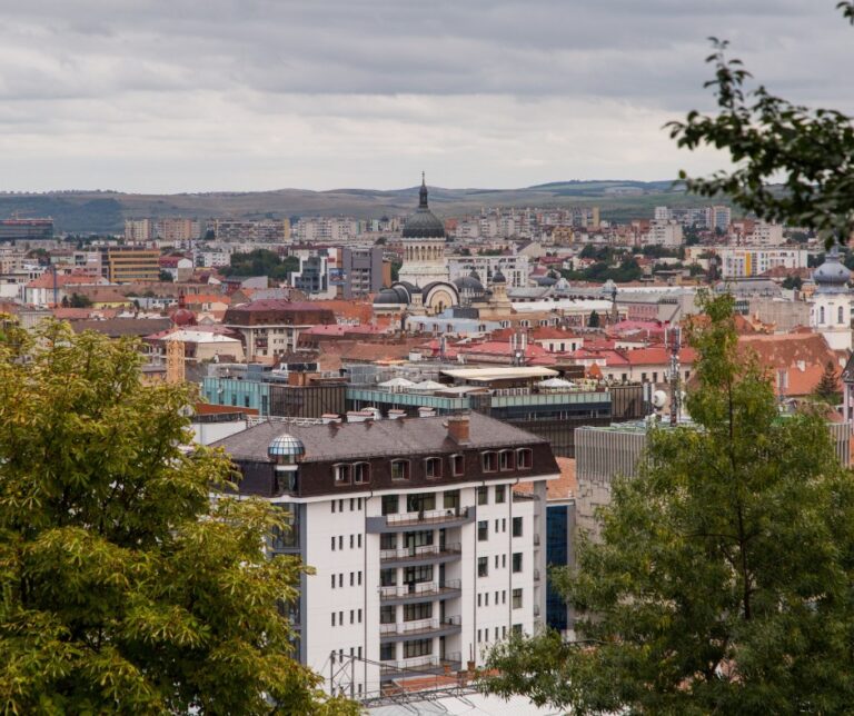 Panoramic view of Cluj-Napoca skyline from Cetățuia Hill, Romania, with the Orthodox Cathedral dome visible above the rooftops