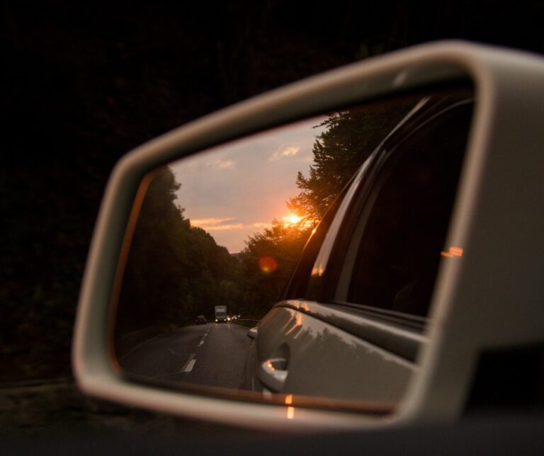 Sunset reflected in a car wing mirror on a road trip through the Carpathian Mountains, Romania