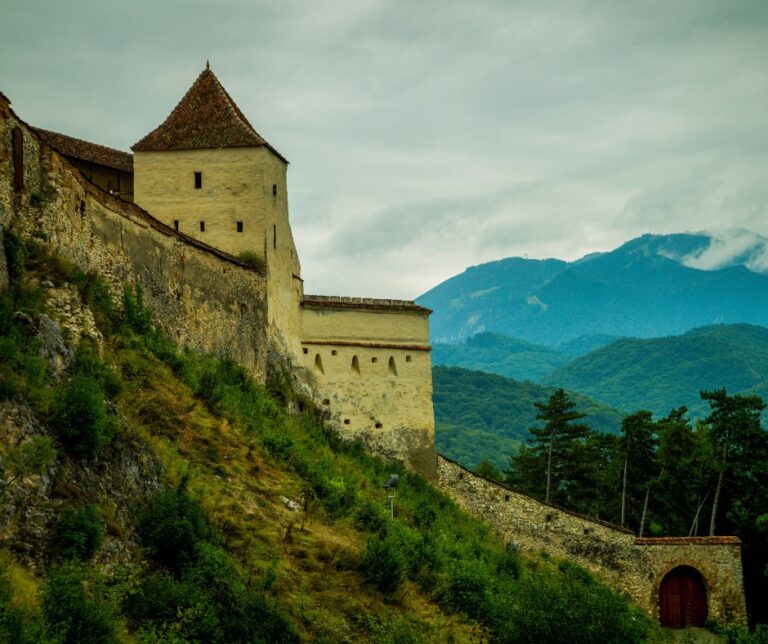 Râșnov Citadel perched on a hillside in Transylvania, Romania, with the Carpathian Mountains visible in the background