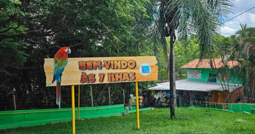 A layered, collage-style image combining black-and-white photos of groups of people with overlapping blocks of distorted, partially illegible text. The text appears scrambled and fragmented, as if glitched or cut and rearranged. Along the bottom, a strip of color shows an outdoor scene with green and yellow railings, trees, and people gathered under a canopy. The overall composition feels chaotic and experimental, blending documentary imagery with abstract text elements.