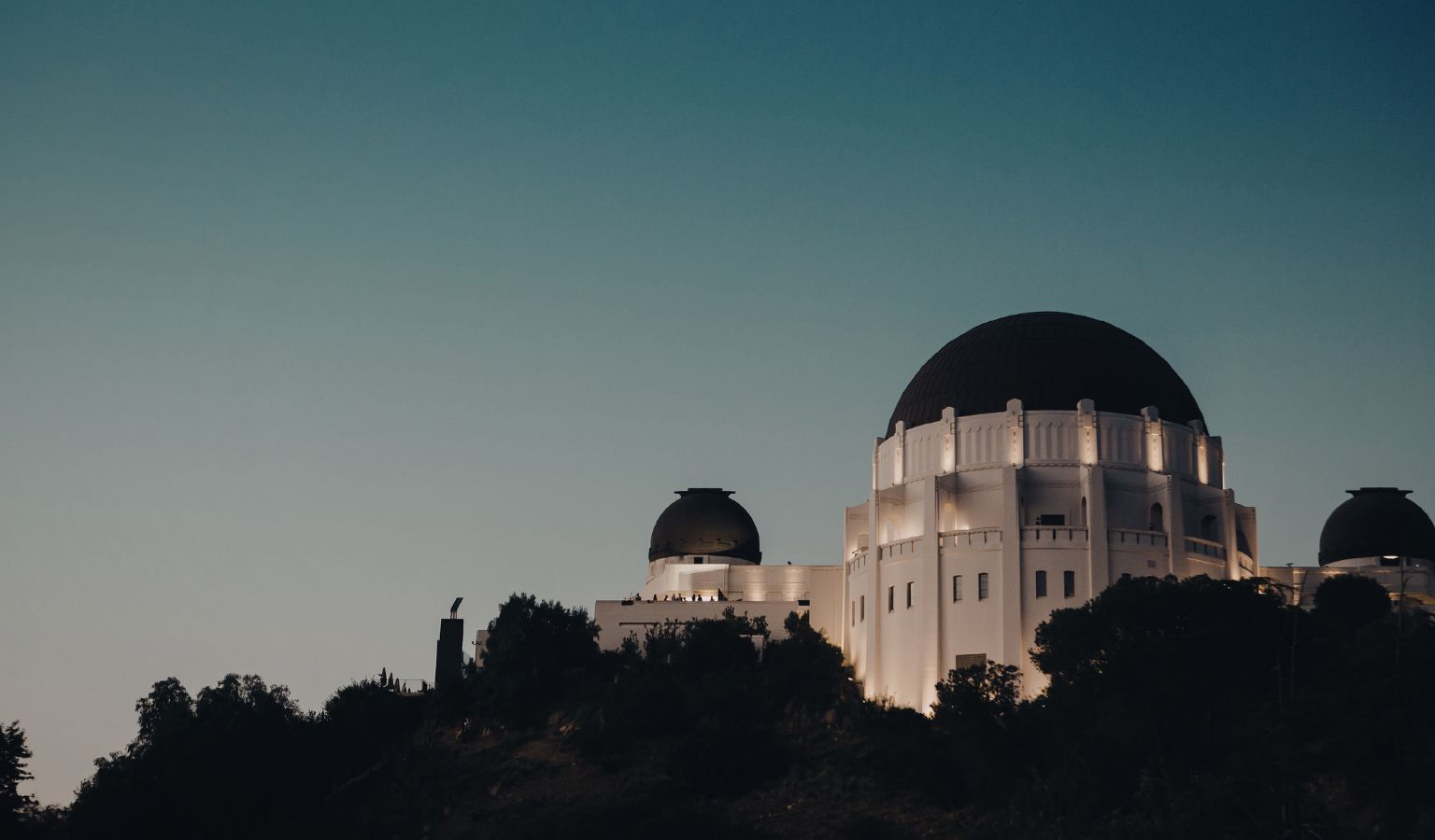 Griffith Observatory lit up at dusk on a hillside in Los Angeles – accessible landmark featured in an accessible guide to LA