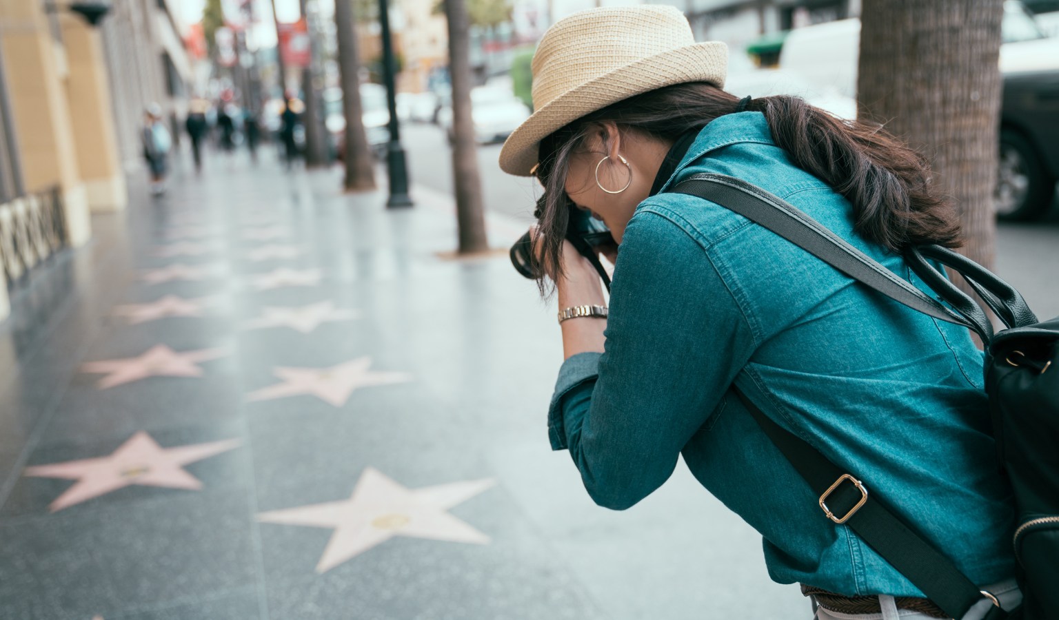 Tourist photographing stars on the Hollywood Walk of Fame along a flat, paved sidewalk in Los Angeles – accessible guide to LA