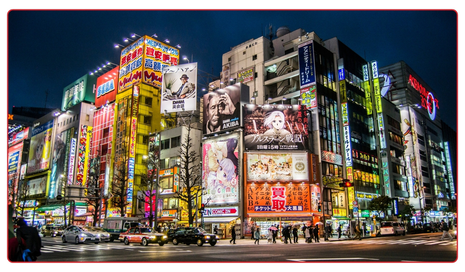 A busy Akihabara street corner in Tokyo at night, lined with tall buildings covered in illuminated signs and advertising billboards